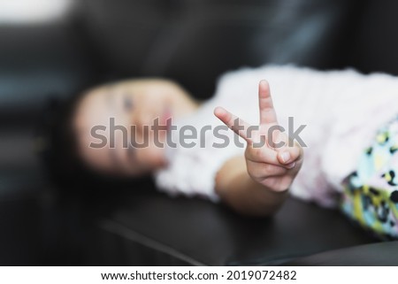 Similar – Image, Stock Photo Female palm with V-sign with rainbow bracelet