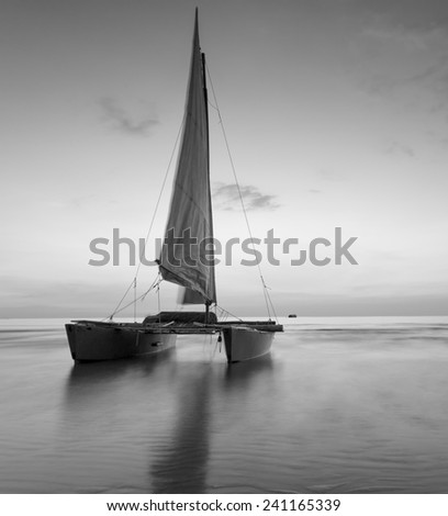 sailboat on the beach with a beautiful sunset in black and white