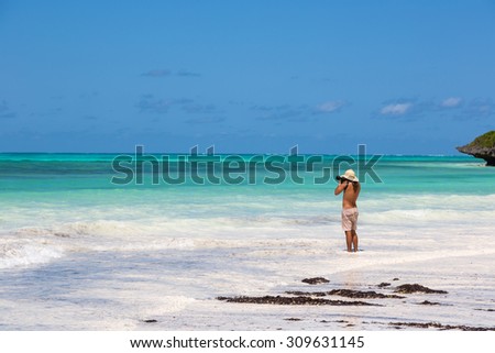 Lonely man enjoying the beautiful beach of Zanzibar, Tanzania, Africa