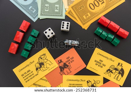 February 8, 2015 - Houston, TX, USA.  Monopoly money, playing pieces and cards