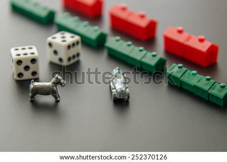 February 8, 2015 - Houston, TX, USA.  Monopoly houses and hotel rows with dice,  car and dog
