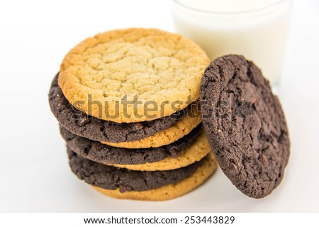 glass of milk and chocolate and sugar cookies stacked