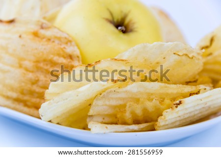 yellow apple vs yellow salty potato chips - snack decision between healthy food or junk food