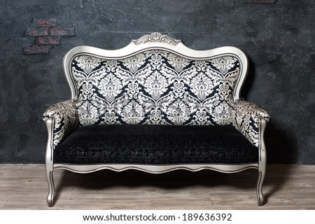 Old-fashioned sofa against the background of black wall