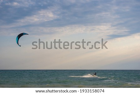 kitesurfer rides a kite-surf on waves of the sea in a small storm on a summer day
