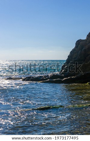 sea landscape is a pebbly beach with waves in white foam, a beautiful sky with clouds, a warm summer day