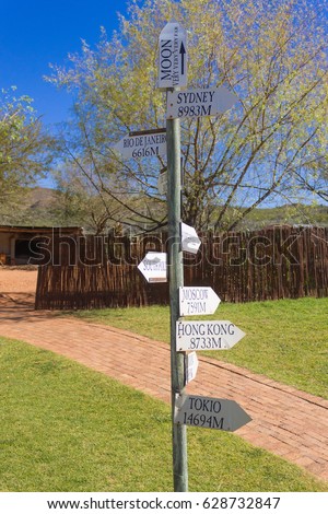 Funny distance signage pole from Oudtshoorn, South africa. Arrows with distance indication