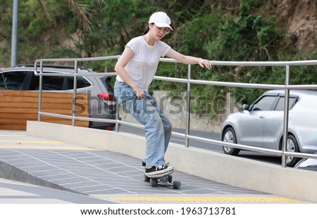 Outdoor sport Lifestyle with surf skate , Happy Young woman play surf skate at park