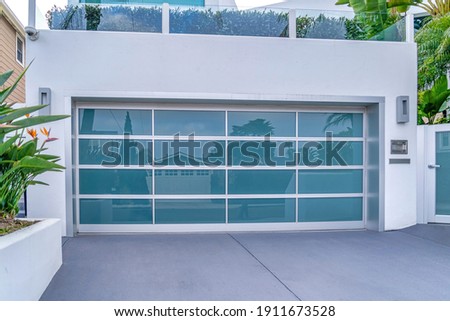 Garage with glass door under balcony with glass railing in San Diego California