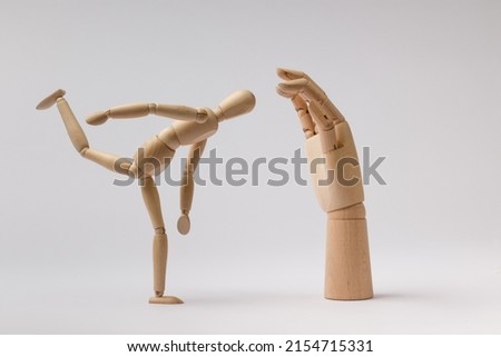 wooden dummy of a man swung his leg to hit a wooden hand on a white background Сток-фото © 