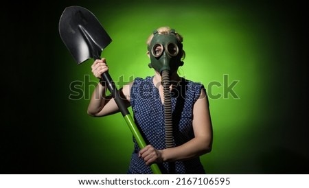 a woman in a gas mask swung a shovel on a dark background, hard light Сток-фото © 