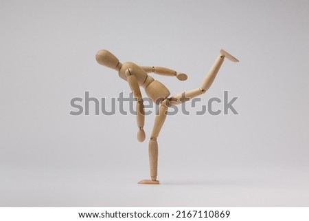 a wooden mannequin of a man swung his leg for a kick on a white background Сток-фото © 