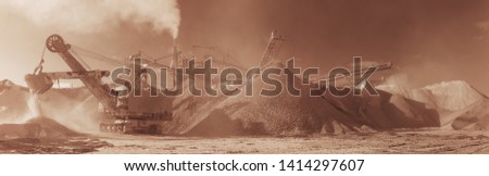 Excavator on the background of stone-crushing equipment at the limestone quarry, monochrome panoramic image of a light brown color, sepia. Mining industry.