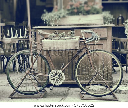 Vintage stylized photo of old bicycle carrying flowers