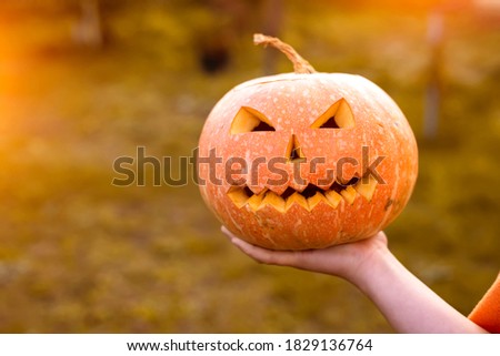 scary Halloween pumpkin in hand