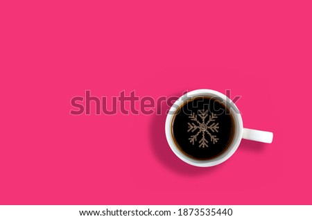 Creative concept with cup of coffee and snowflake made of coffee foam. Flat lay design