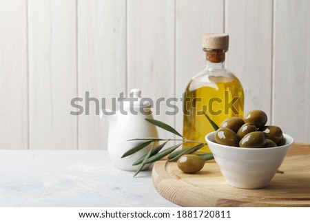 Composition of green olives, oil, spices, gravy boats, on a white background.