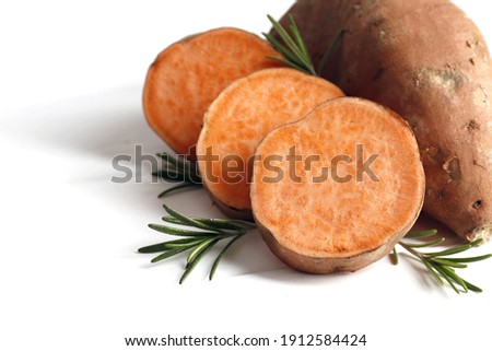 Sweet potatoes and rosemary spice on table against color background