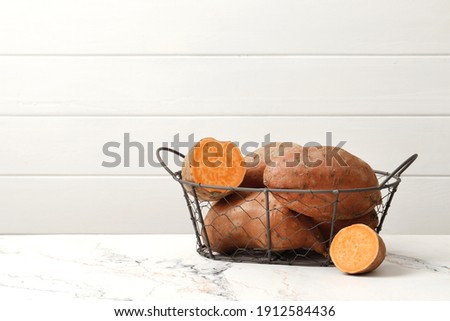 Composition of Fresh ripe sweet potatoes on a marble table background