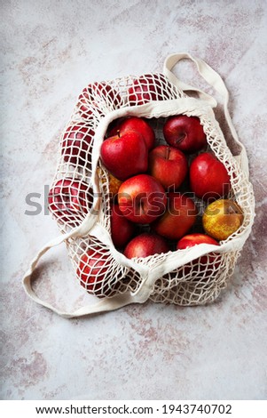 Apples starking in the mesh bag. Sustainability and conscious consuming concept. Top View. Flat Lay