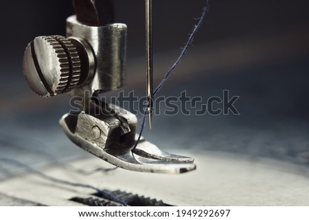 Close up of sewing machine needle with thread. Working part of antique sewing machine.