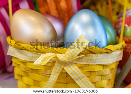 Bow on a basket close up. Easter colored eggs defocused on a blurred background. Background with place for text or copy space.