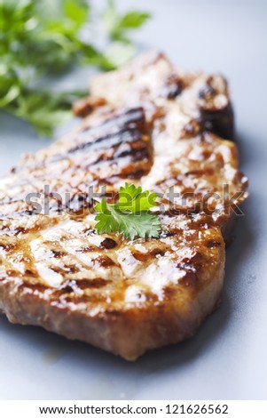 juicy grilled pork chop (neck cut) with greens