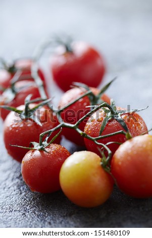 fresh wet tomatoes on wet stone surface