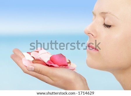 female holding (silk) rose petals up to her nose