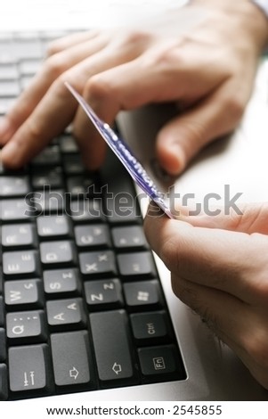 typing in credit card details, very shallow dof, fucus at the edge of card