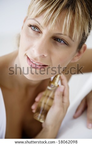 young female applying perfume (the bottle is a generic \