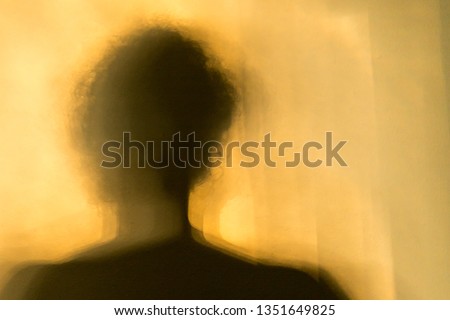 Shadow of the figure of a man or woman with a yellow orange background