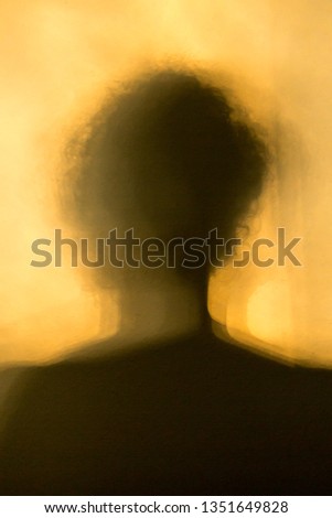 Shadow of the figure of a man or woman with a yellow orange background