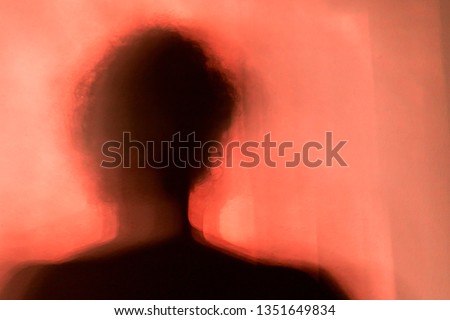 Shadow of the figure of a man or woman with a red pink background