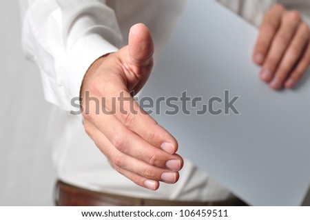 Open handshake and paperwork pose conveying job interview or acceptance