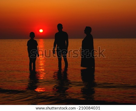 Three generations on the sea at the sunrise. New beginning concept.