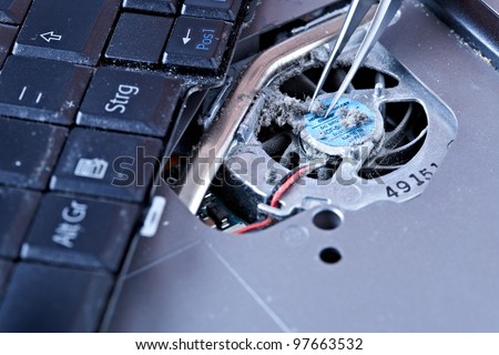 macro of tweezers on a laptop fan