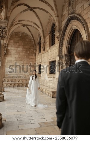 Similar – Image, Stock Photo Beautiful newlyweds hugging near the ancient door. Wedding portrait of a stylish groom and a young bride near old house in in a European town