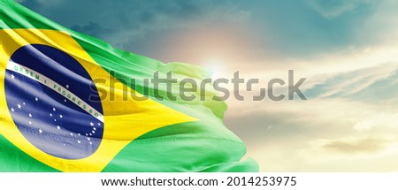 Brazil national flag waving in beautiful sky.