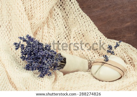 Exquisite natural soap garnished with twigs of lavender and a bunch of dried lavender in a canvas bag
