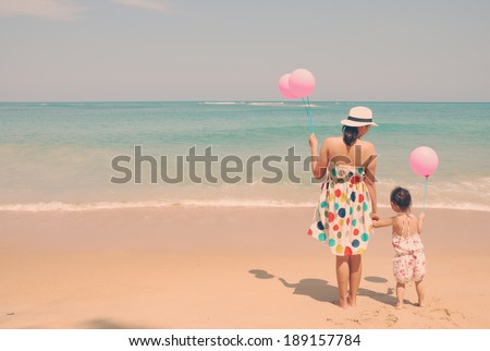 Mother and  kid on the beach with pink balloons vintage , happy mothers day vintage retro style