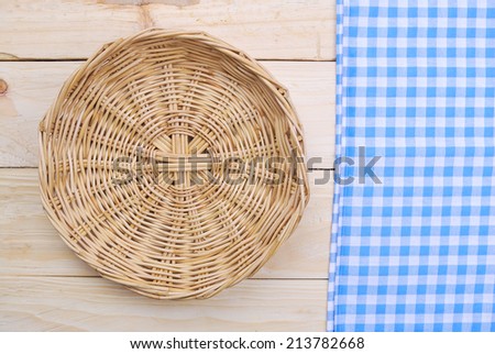 Rattan plate or basket on wooden table and tablecloth on table wood plank made for background
