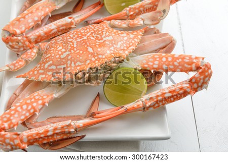 Red crabs on a plate, Boiled crabs with lime on the wood white background