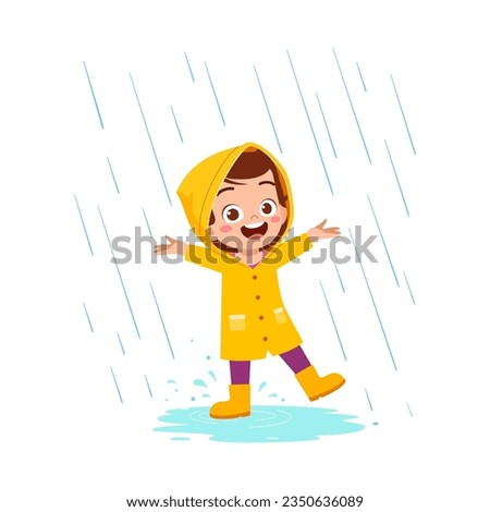 little kid wearing yellow rain coat in the rain and feel happy