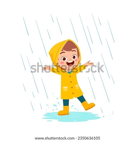 little kid wearing yellow rain coat in the rain and feel happy