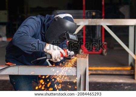 Metal workers use manual labor. Skilled welder.Technicians use steel cutting tools to cut steel. Metal cutting. Worker electric saw wheel grinding cutting
 a steel in factory. Сток-фото © 