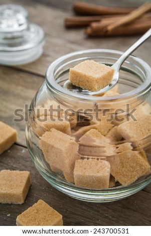 Brown sugar cubes in spoon on jar