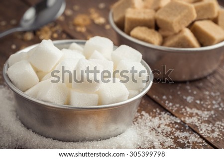 White sugar and brown sugar in bowl on wooden table
