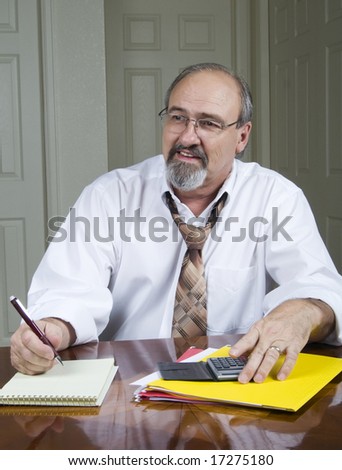 A businessman smiles across the table at one of his co-workers.
