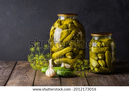 Pickled cucumbers in the jar. Ingredients for pickling cucumbers. Cucumbers, dill, garlic. Glass jars with pickles